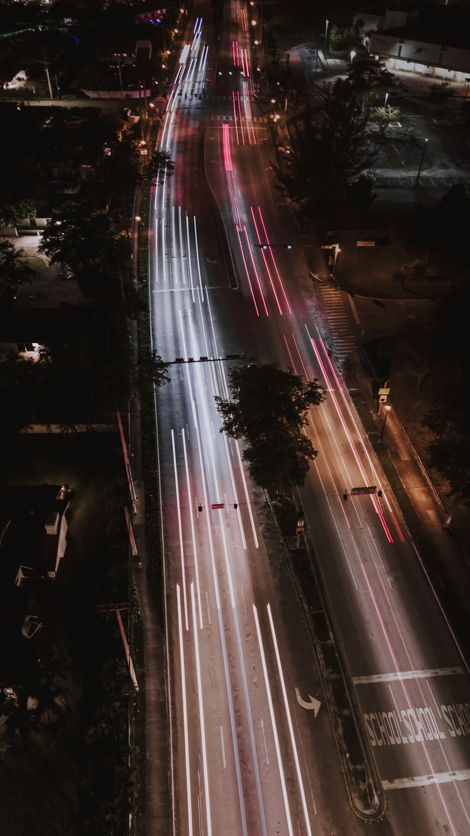 Aerial long exposure of red and white light trails on a highway at night